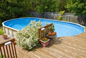 Wooden Above-Ground Side Pool Deck in Leafy Backyard via Fixr